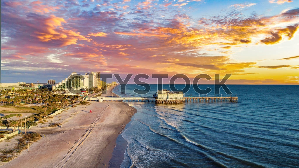 Colorful sunset at Daytona Beach with pier and skyline