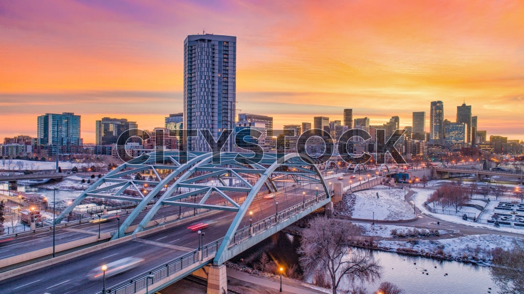 Warm sunset over Denver skyline with distinctive bridge
