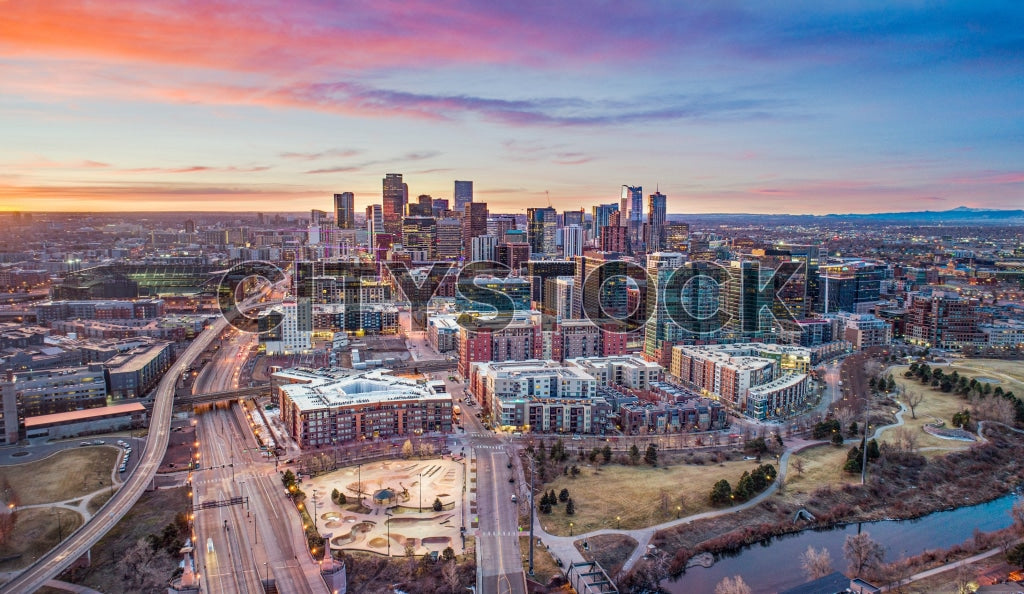 Aerial view of Denver skyline at sunrise with Rockies in the distance