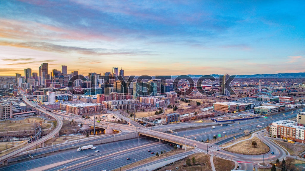Aerial view of Denver skyline and highways during sunset