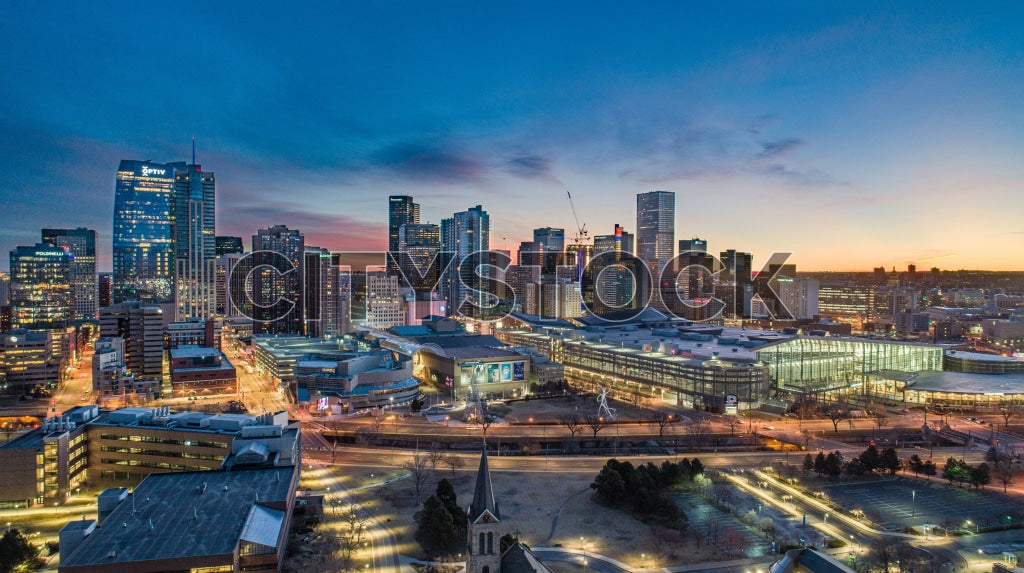 Aerial view of Denver skyline at twilight with illuminated buildings