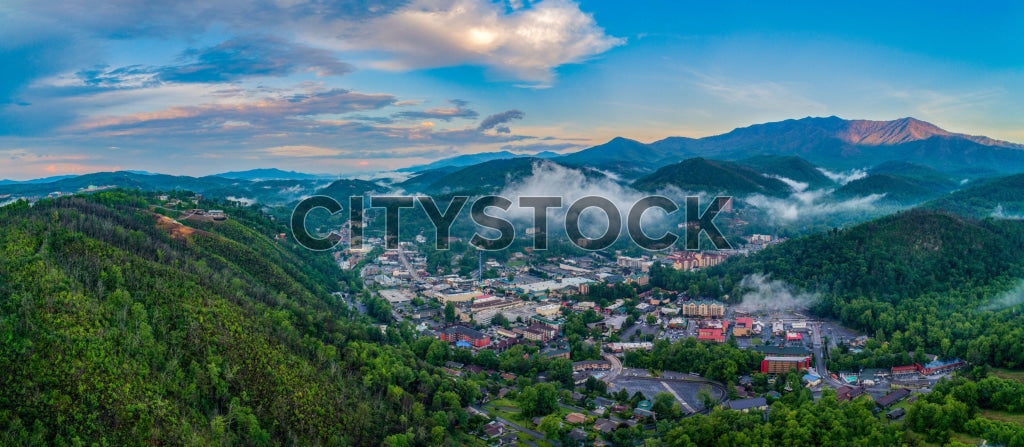 Aerial view of Gatlinburg, TN with misty mountains at sunrise