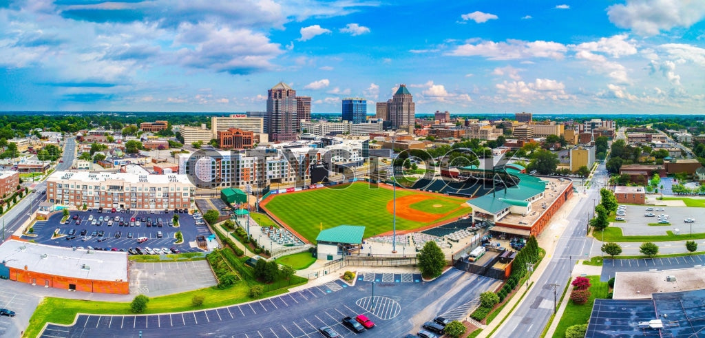 Aerial view of Greensboro, NC showcasing downtown skyline and baseball field
