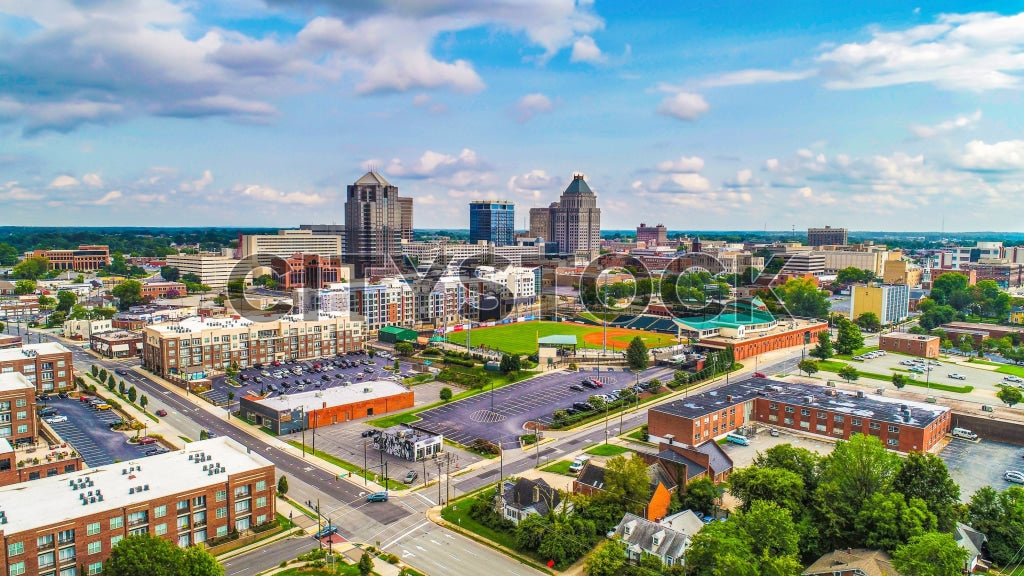 Aerial panorama of Greensboro NC featuring urban skyline and blue sky
