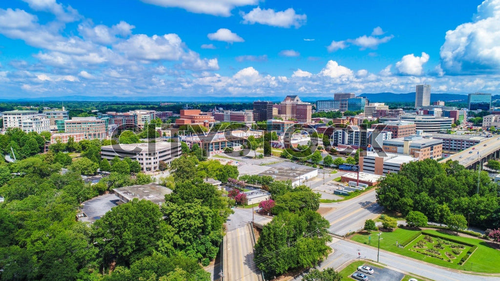 Aerial cityscape of Greenville, South Carolina, under bright blue sky