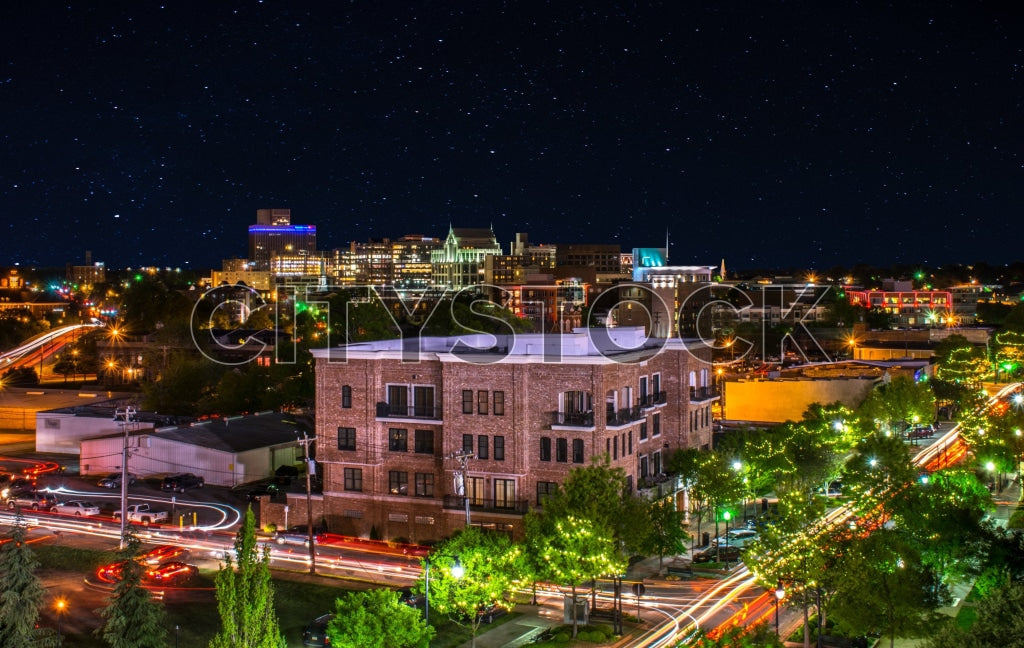 Greenville SC skyline at night with stars and traffic light trails
