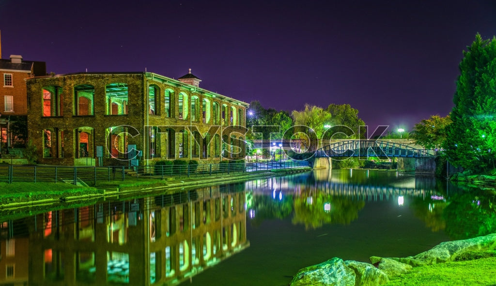 Greenville SC historical buildings lit at night by riverside