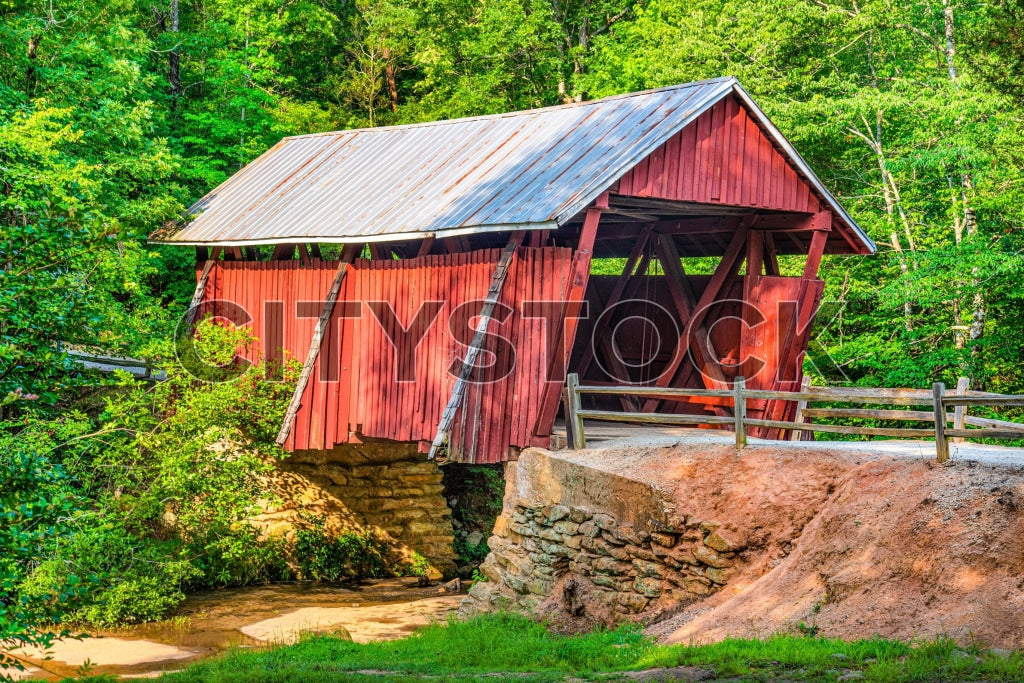 Historic red covered bridge in lush forest setting, Greenville