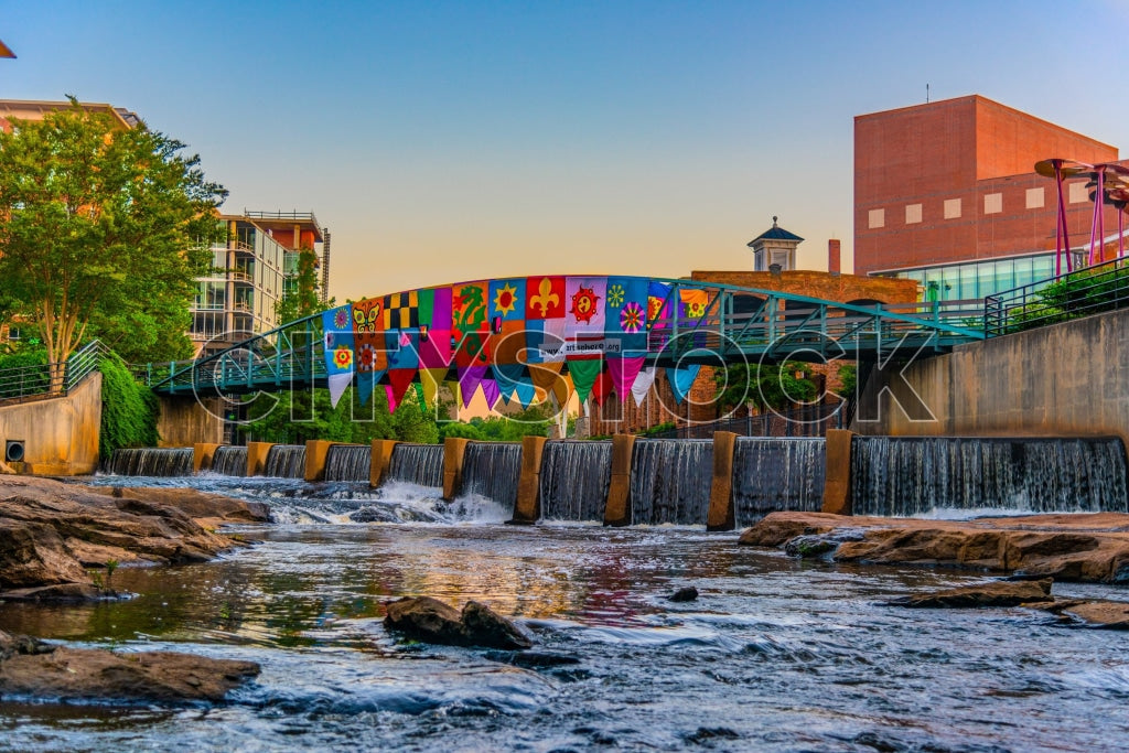 Colorful footbridge over river at sunset in Greenville