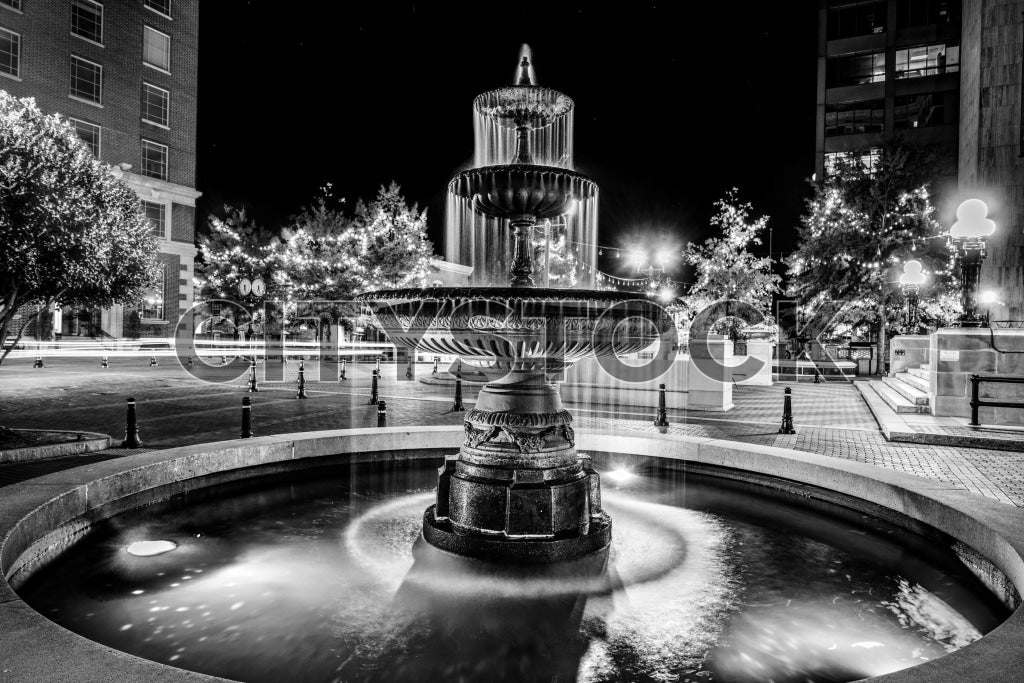 Elegant nighttime view of a tiered fountain in Greenville in black and white