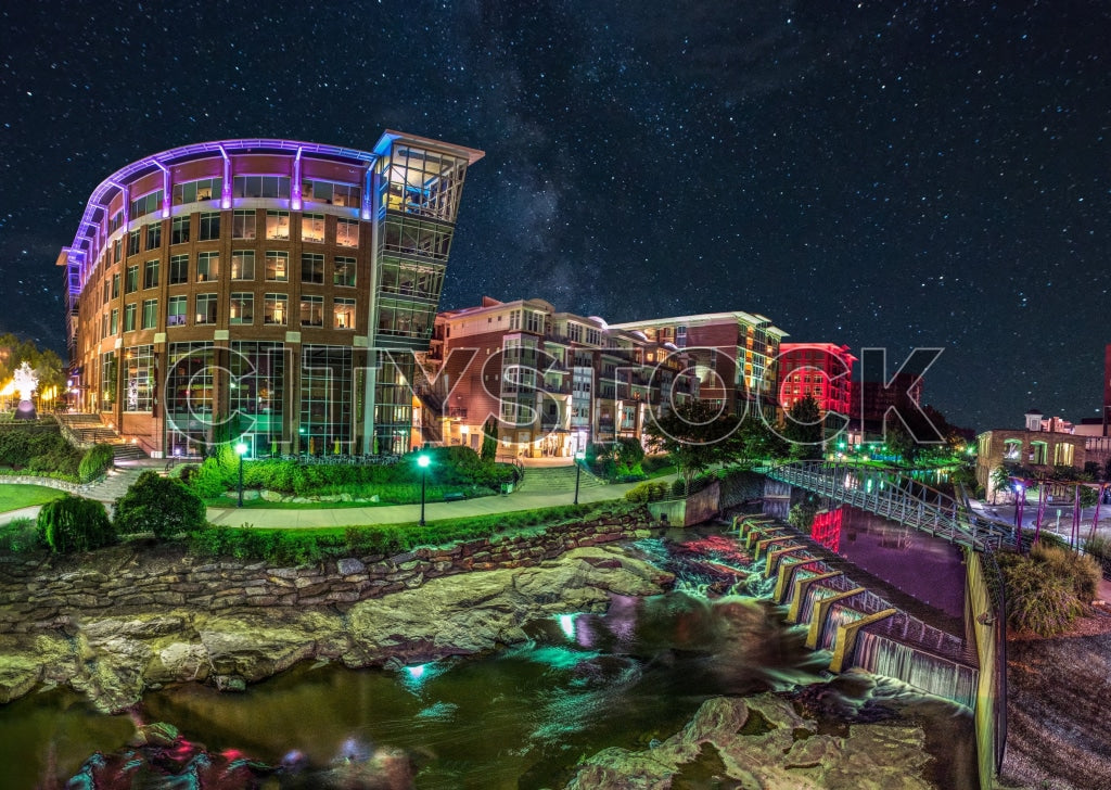 Greenville, SC riverside cityscape illuminated at night under stars