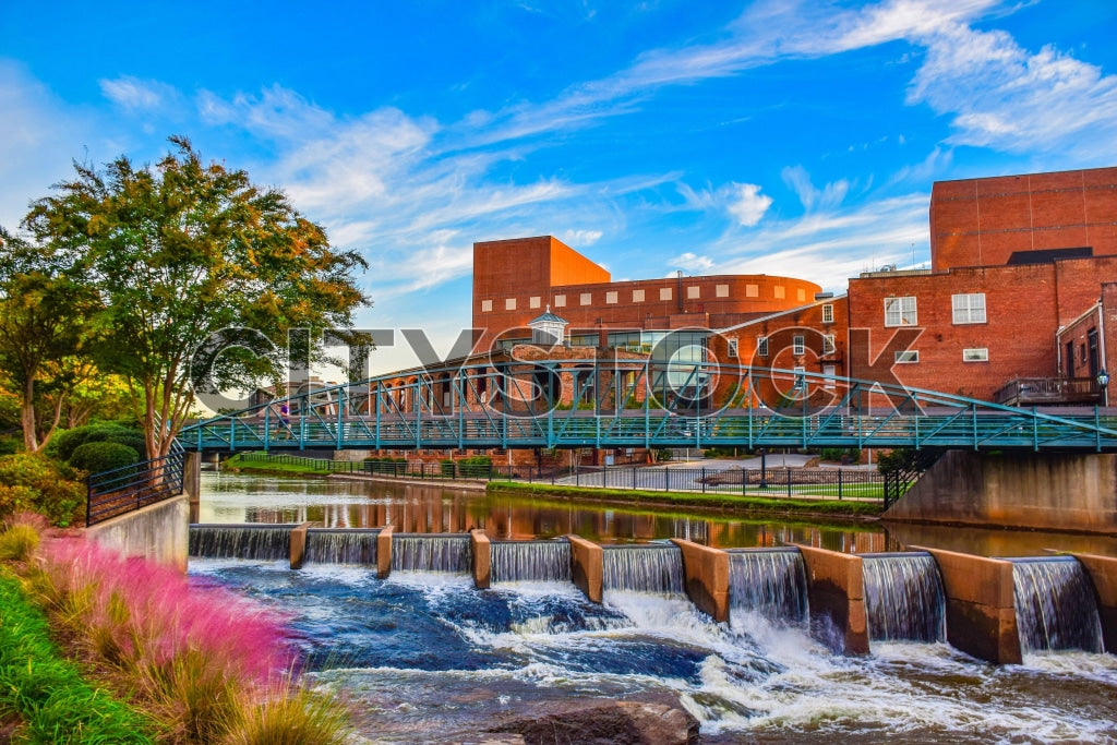 Scenic view of sunset over Reedy River with pedestrian bridge in Greenville, SC