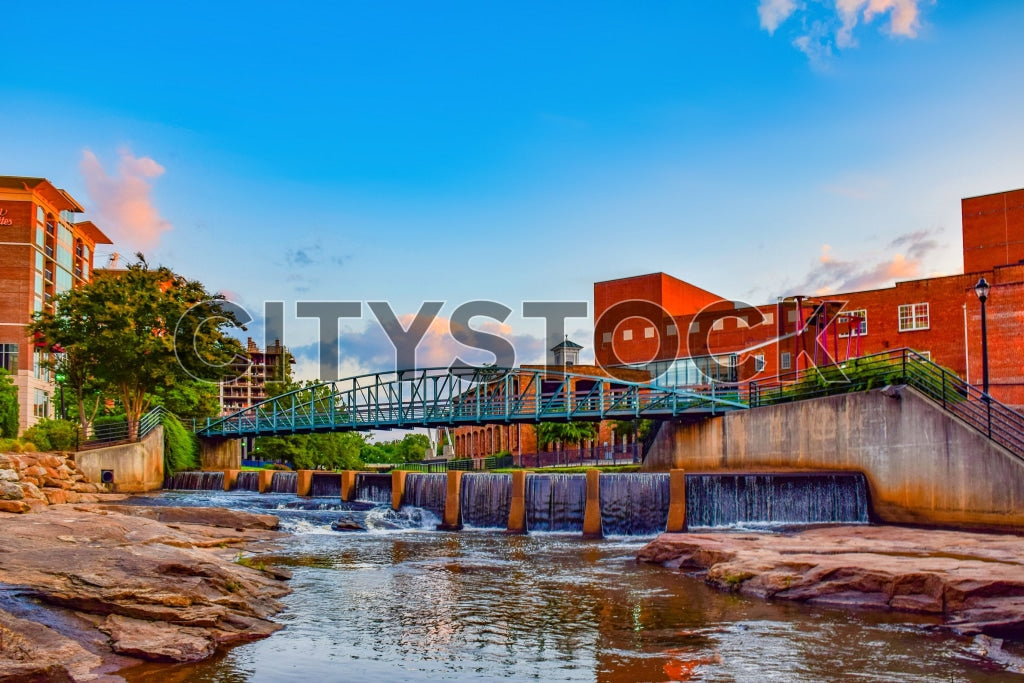 Sunset view at Greenville Riverwalk featuring waterfall and bridge