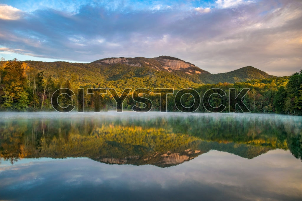 Misty sunrise over tranquil lake with forest and Table Rock, Greenville, SC
