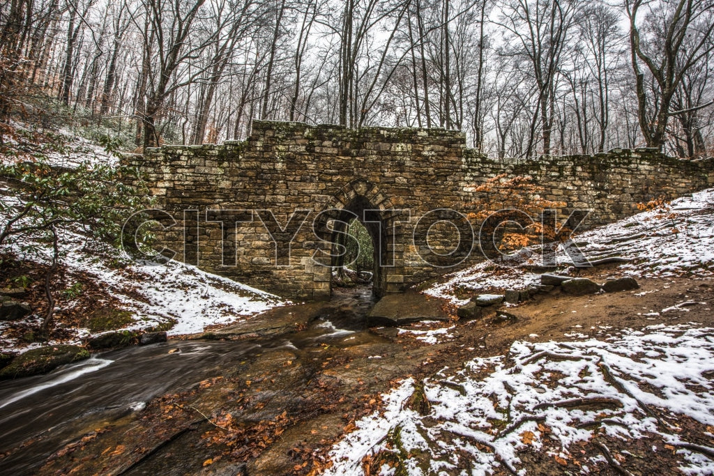 Historic stone bridge over creek in snowy Greenville, SC