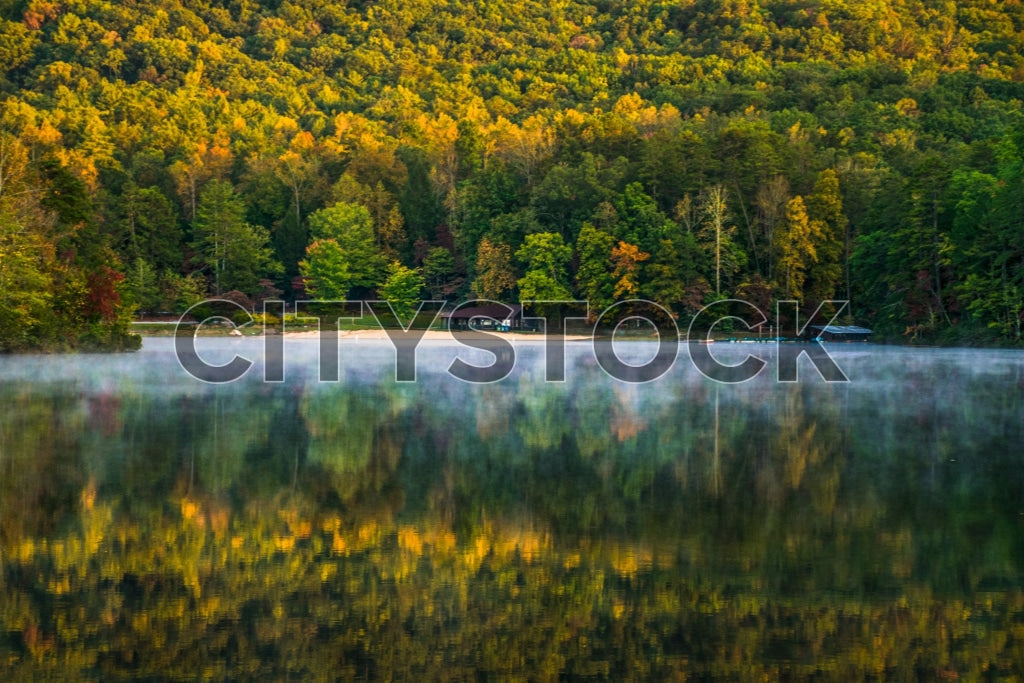 Autumn morning mist over lake with forest reflection in Greenville