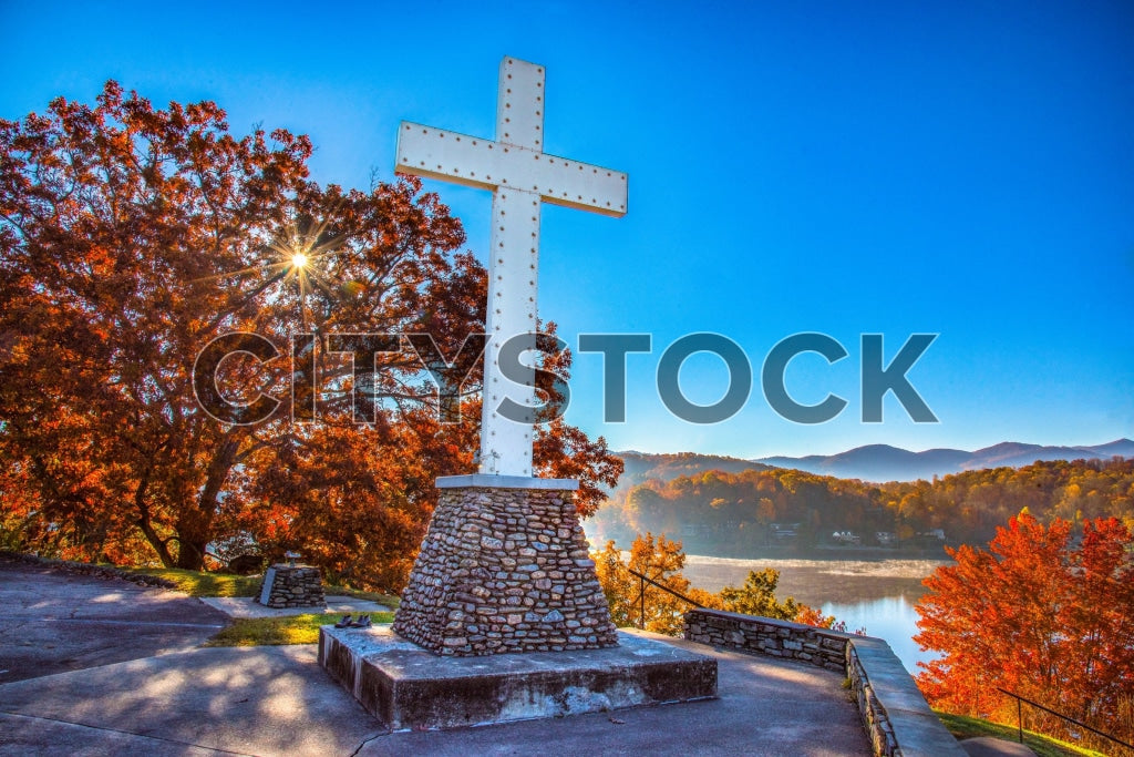 Autumn sunrise at Lake Junaluska, North Carolina with a large white cross and colorful leaves