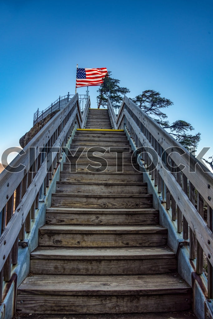 American flag waving atop a stairway against a blue sky in Lake Lure, NC