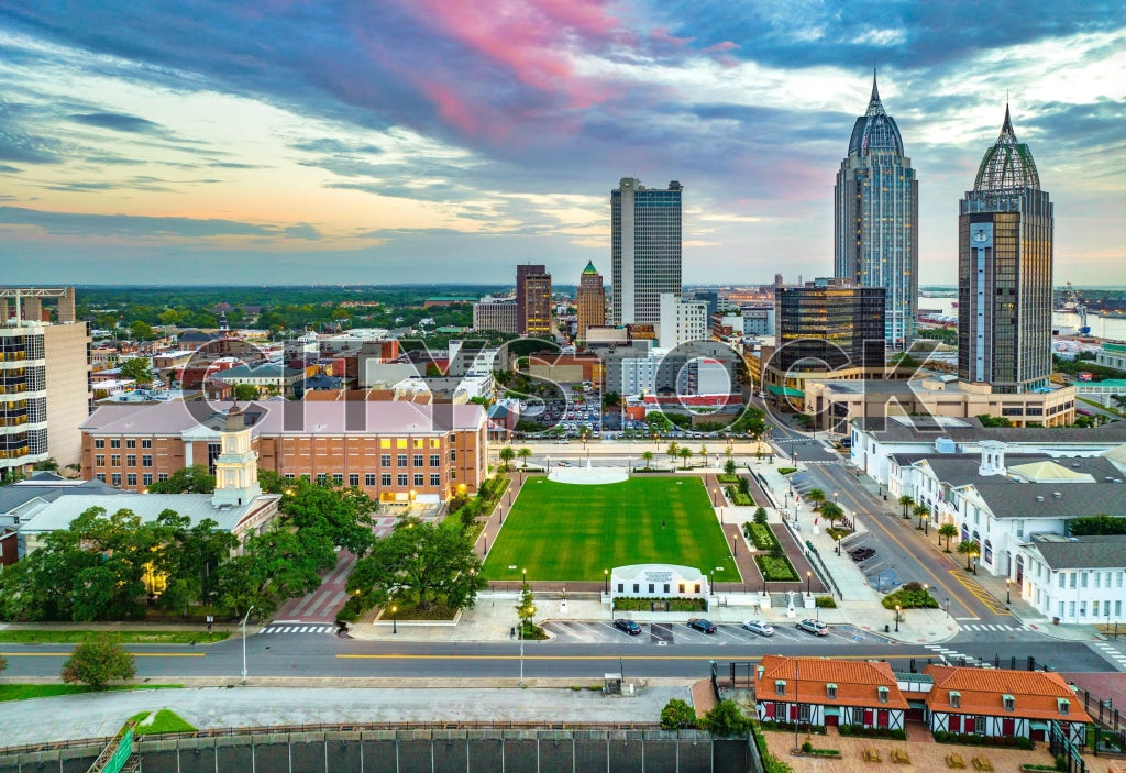 Aerial view of Mobile, Alabama cityscape at sunset with colorful sky