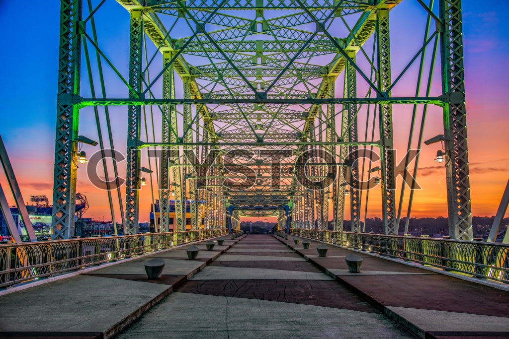 Warm sunset over Nashville's iconic steel bridge with city silhouettes