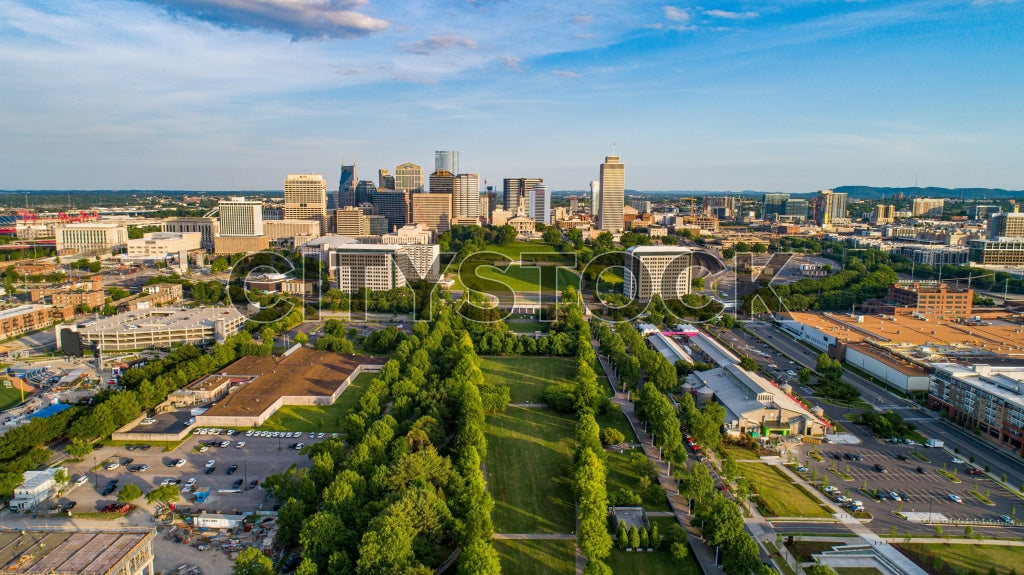 Aerial view of Nashville skyline with clear blue sky and green foreground