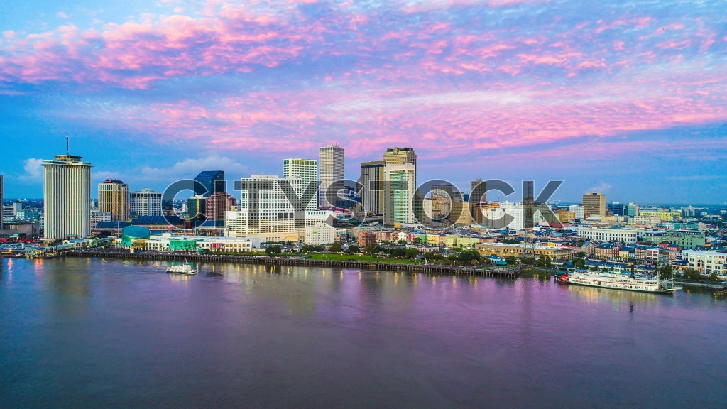 Aerial view of New Orleans skyline at sunrise with pink blue sky