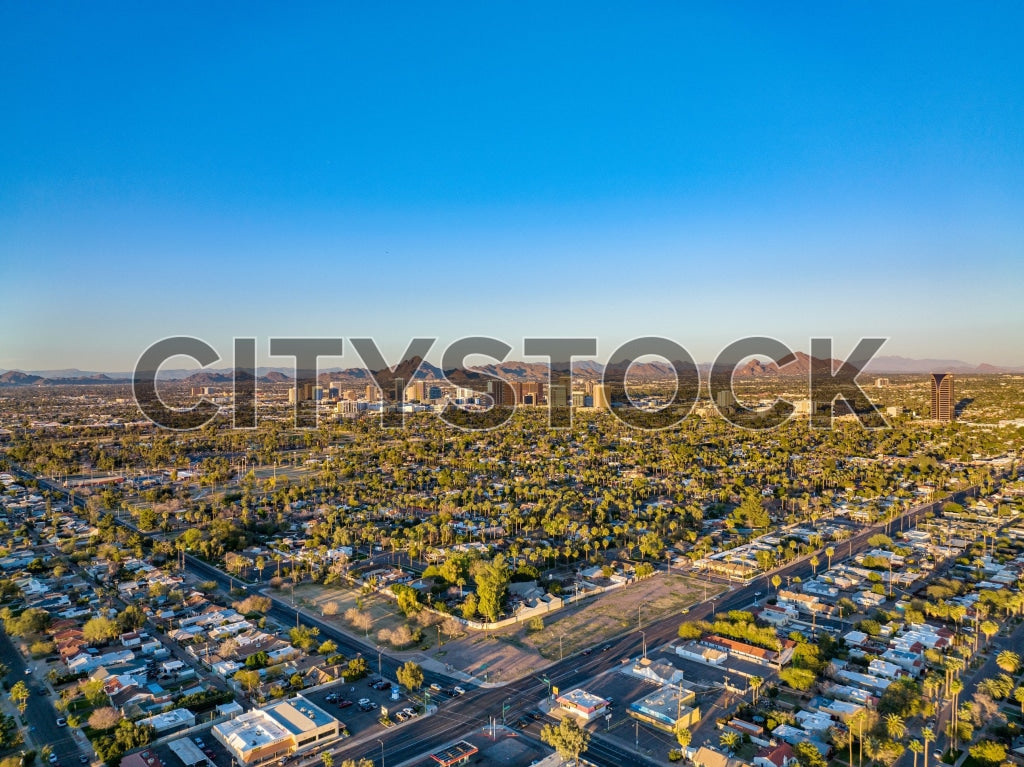 Aerial view of Phoenix cityscape during sunset with blue sky and lush areas