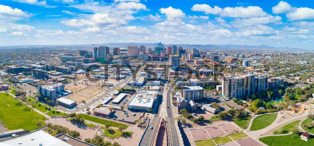 Aerial view of sunny Phoenix skyline showing buildings, roads, and parks