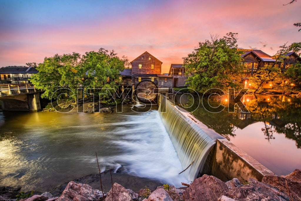 Sunset over waterfall and rustic buildings in Pigeon Forge