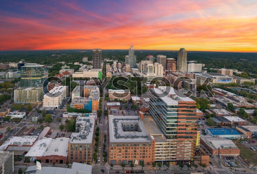 Aerial view of Raleigh, NC cityscape showing vivid sunset