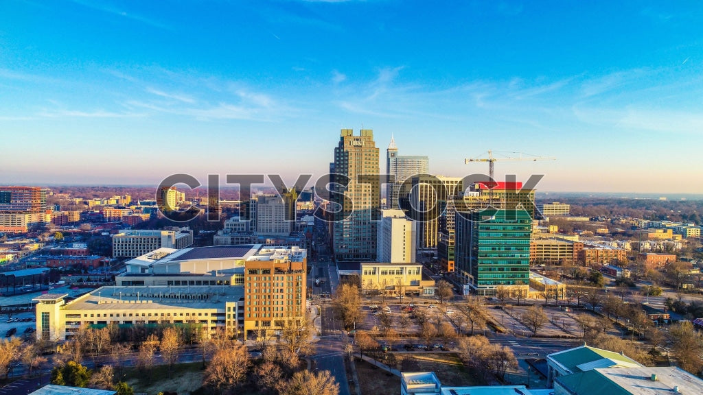 Aerial view of Raleigh cityscape at sunrise with illuminated buildings
