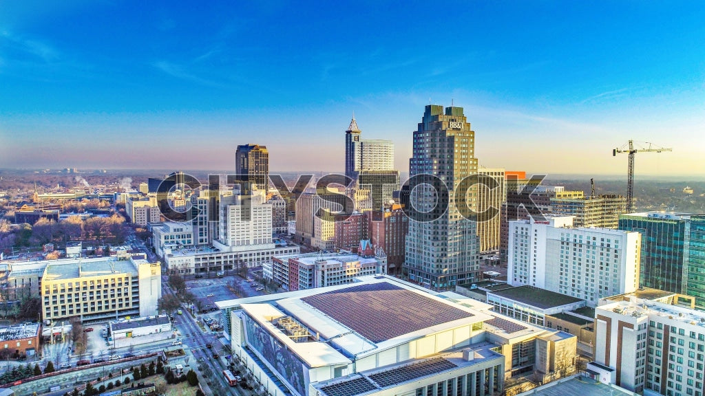 Aerial photo of Raleigh, NC showing modern cityscape at sunset