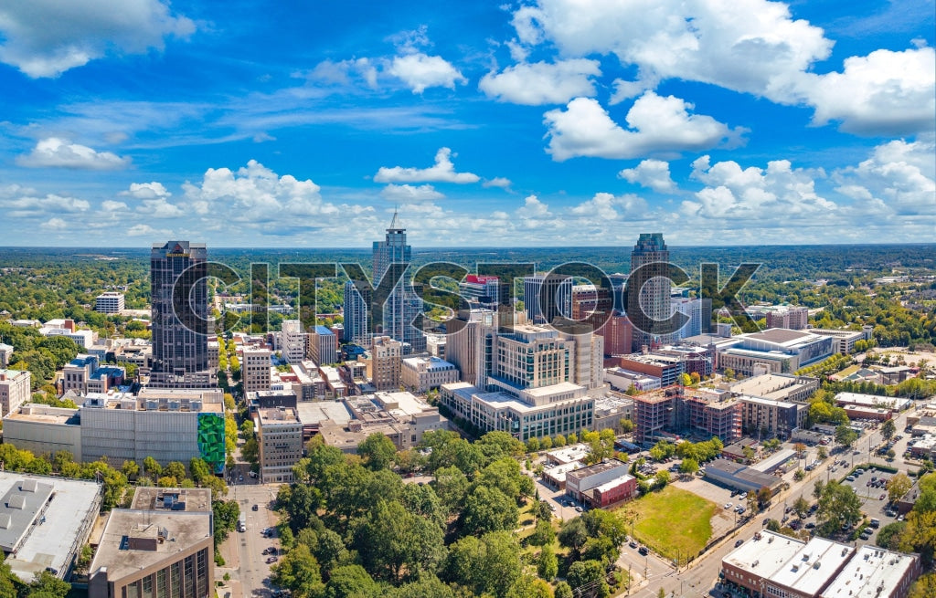 Aerial view of Raleigh's downtown skyscrapers and streets under a blue sky