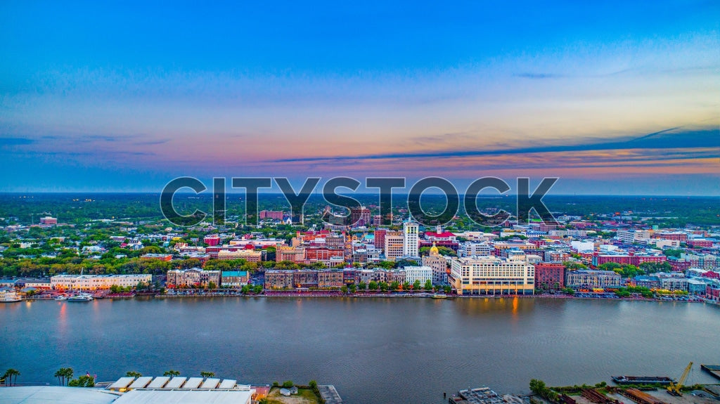 Aerial view of Savannah riverfront at sunset with urban skyline