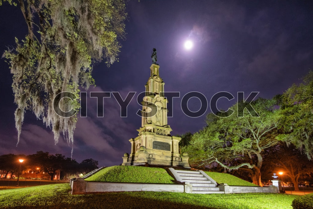 Historic Savannah monument at night under full moon with Spanish moss