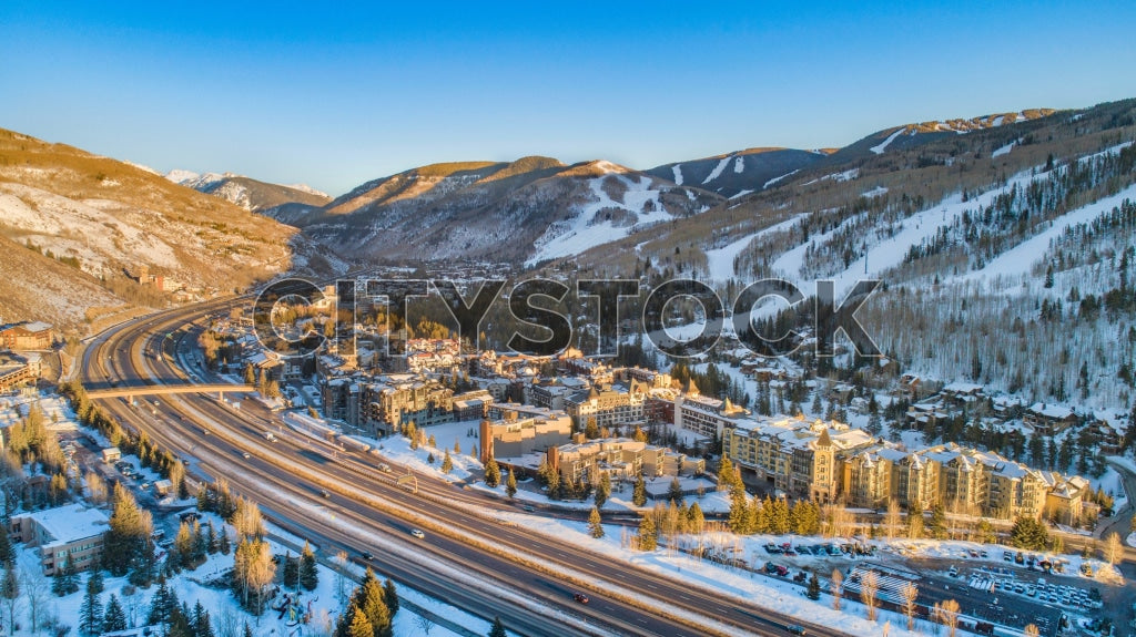 Aerial view of snowy Vail, Colorado at sunrise, with glowing mountains