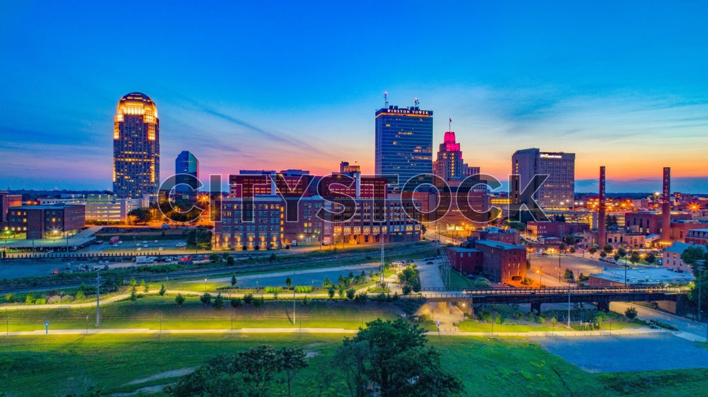 Aerial view of Winston-Salem NC skyline at sunset, featuring vibrant city lights